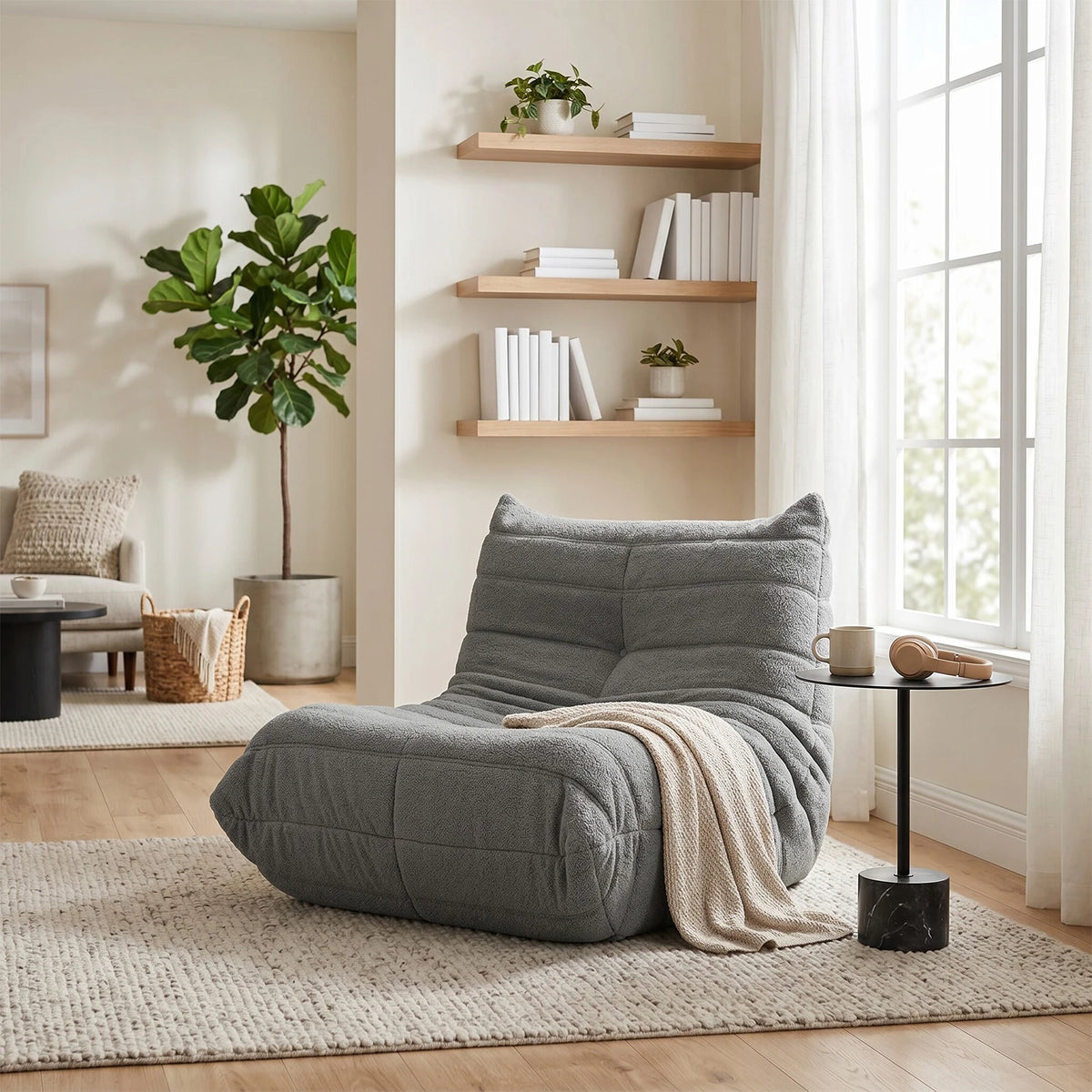 Dune, fauteuil lounge bas gris près d'une bibliothèque